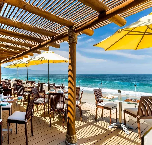 Terraza del restaurante de Buenaventura Grand con sombrillas amarillas frente al mar